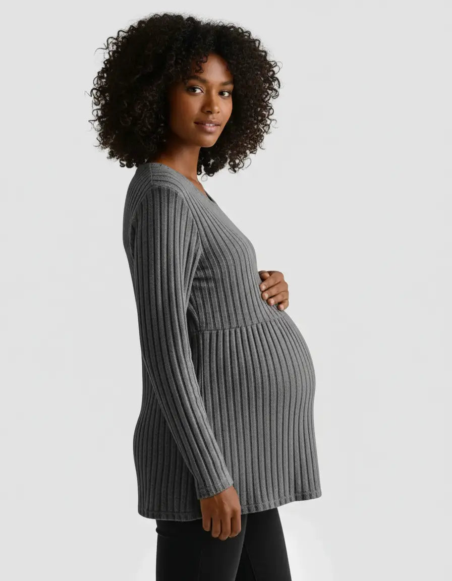 Maternity model in a gray stretch-ribbed casual-fit long-sleeve top, gently holding her baby bump.