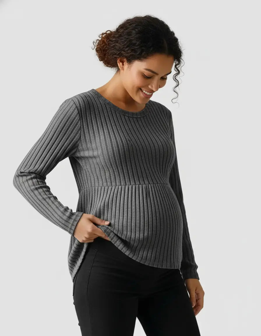 Smiling pregnant woman in a gray stretch-ribbed maternity top with a peplum hem.