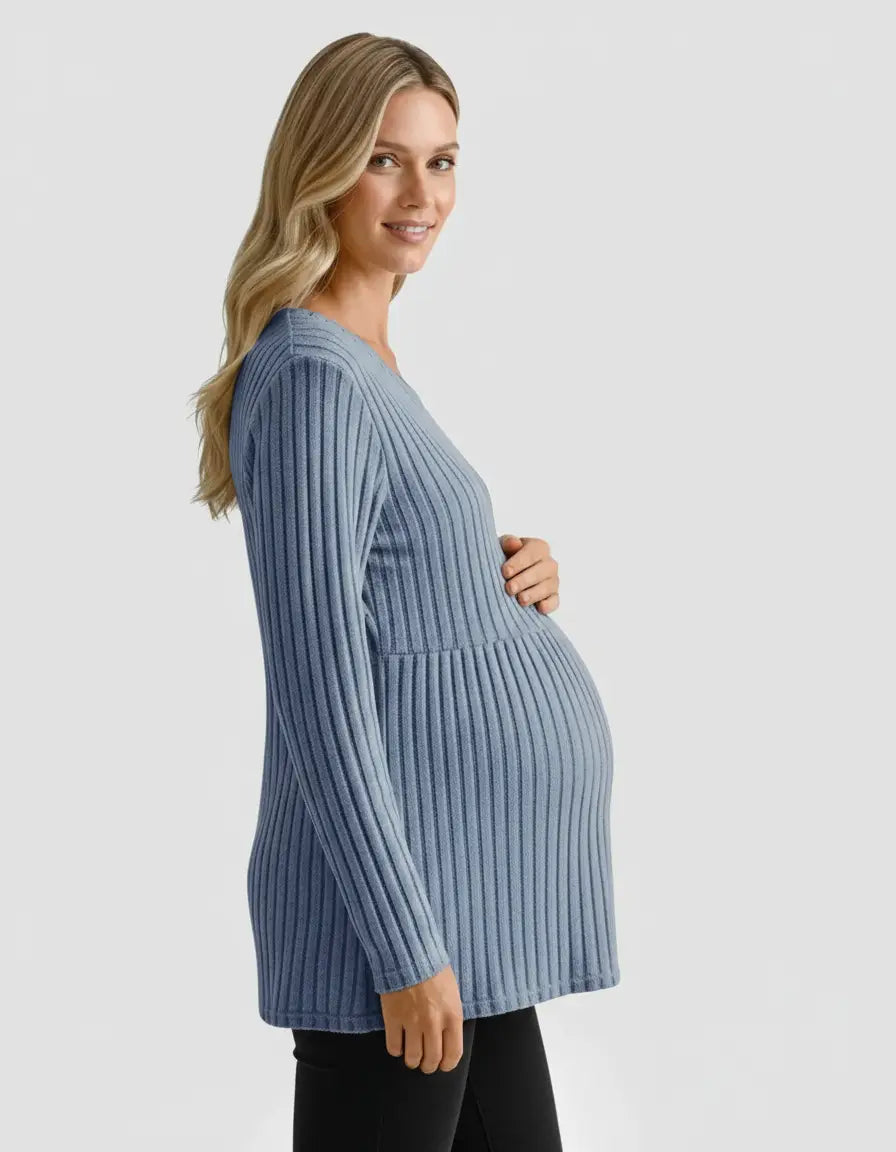 Smiling pregnant woman in a blue stretch-ribbed casual-fit maternity top, holding her belly.
