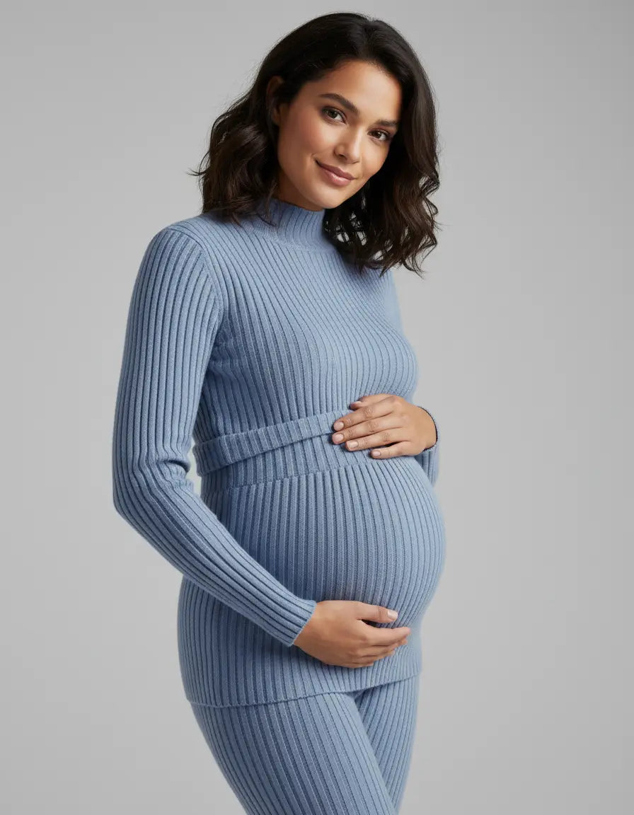 Smiling pregnant woman in a blue stretch-ribbed casual-fit maternity top with a mock neck.