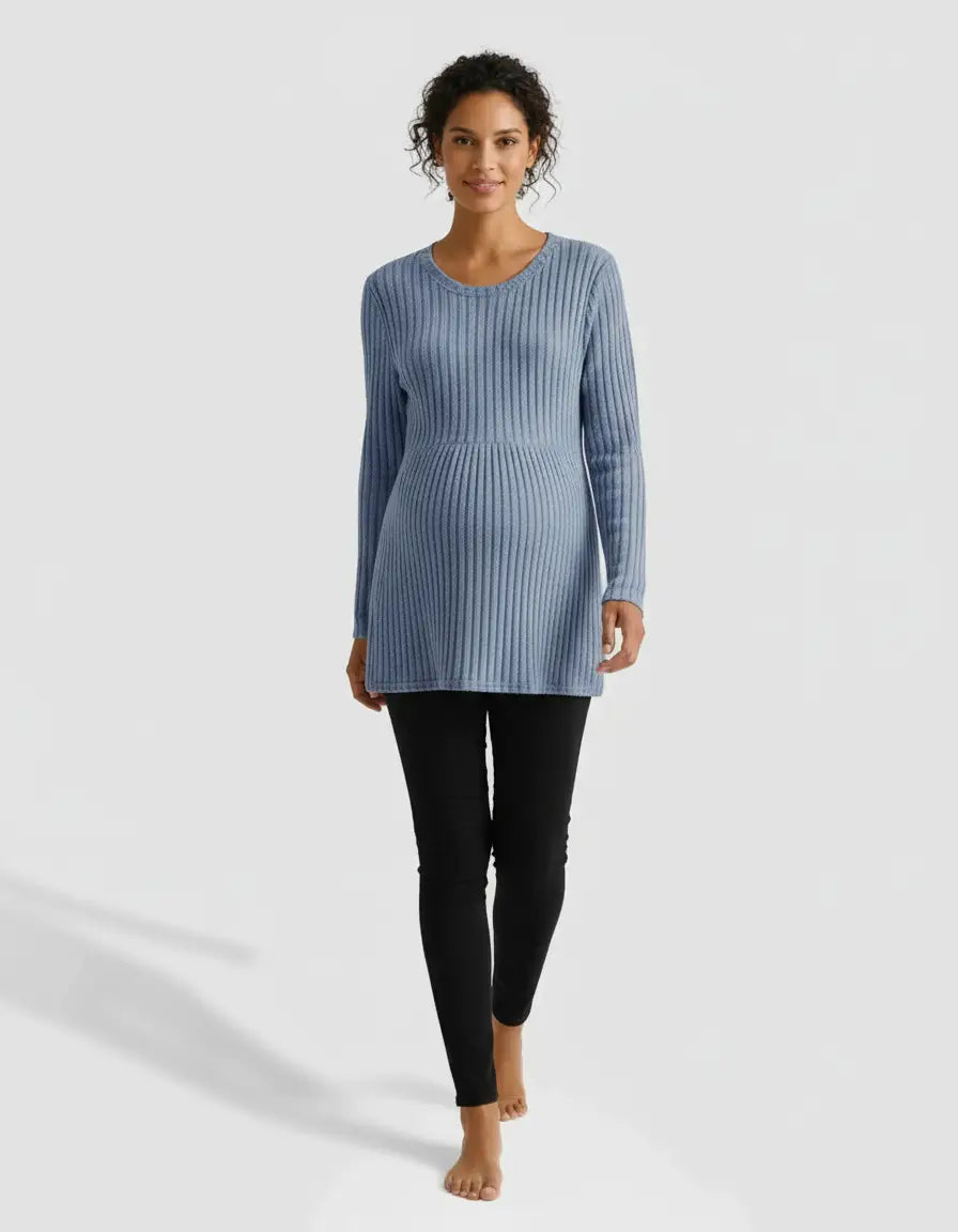 Smiling pregnant woman in a blue stretch-ribbed casual-fit maternity top and black leggings.
