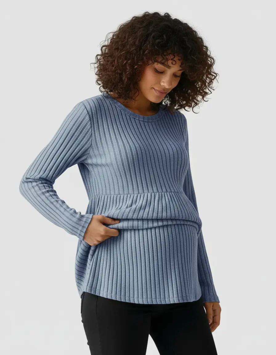 Woman in a blue stretch-ribbed casual-fit maternity top, designed for comfort and adaptability.