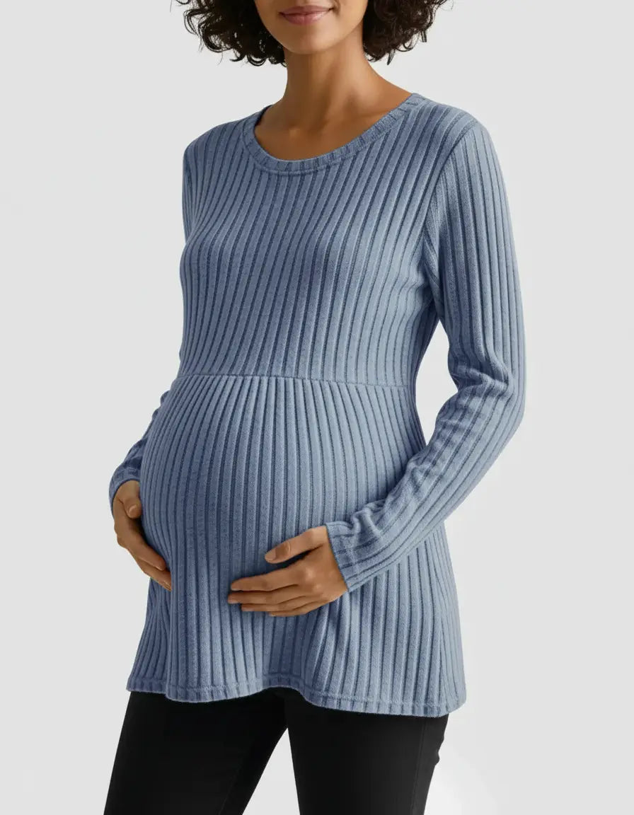 Maternity top: woman in a blue stretch-ribbed, long-sleeve, casual-fit top, hands on her baby bump.