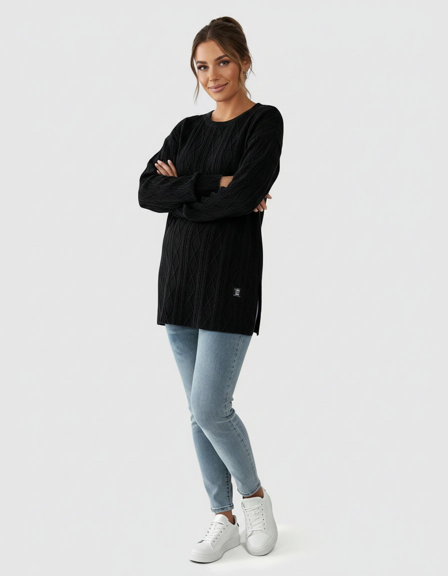 Woman in black textured loose-fit maternity top with side slits, light wash jeans, and white sneakers.