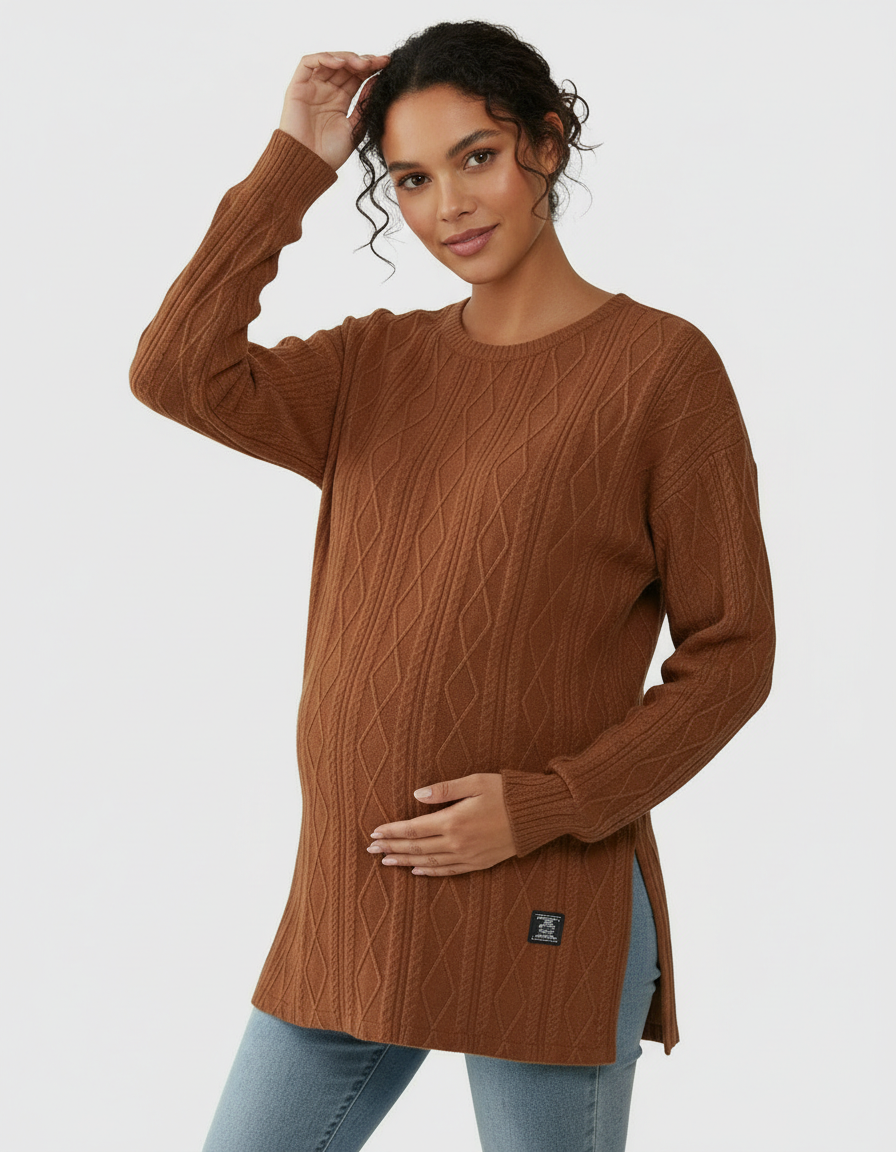 Pregnant woman in a brown textured cable knit loose-fit maternity top with side slits, touching her belly.