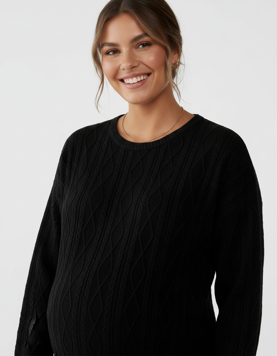 Smiling pregnant model wearing a black textured loose-fit maternity top with long sleeves.
