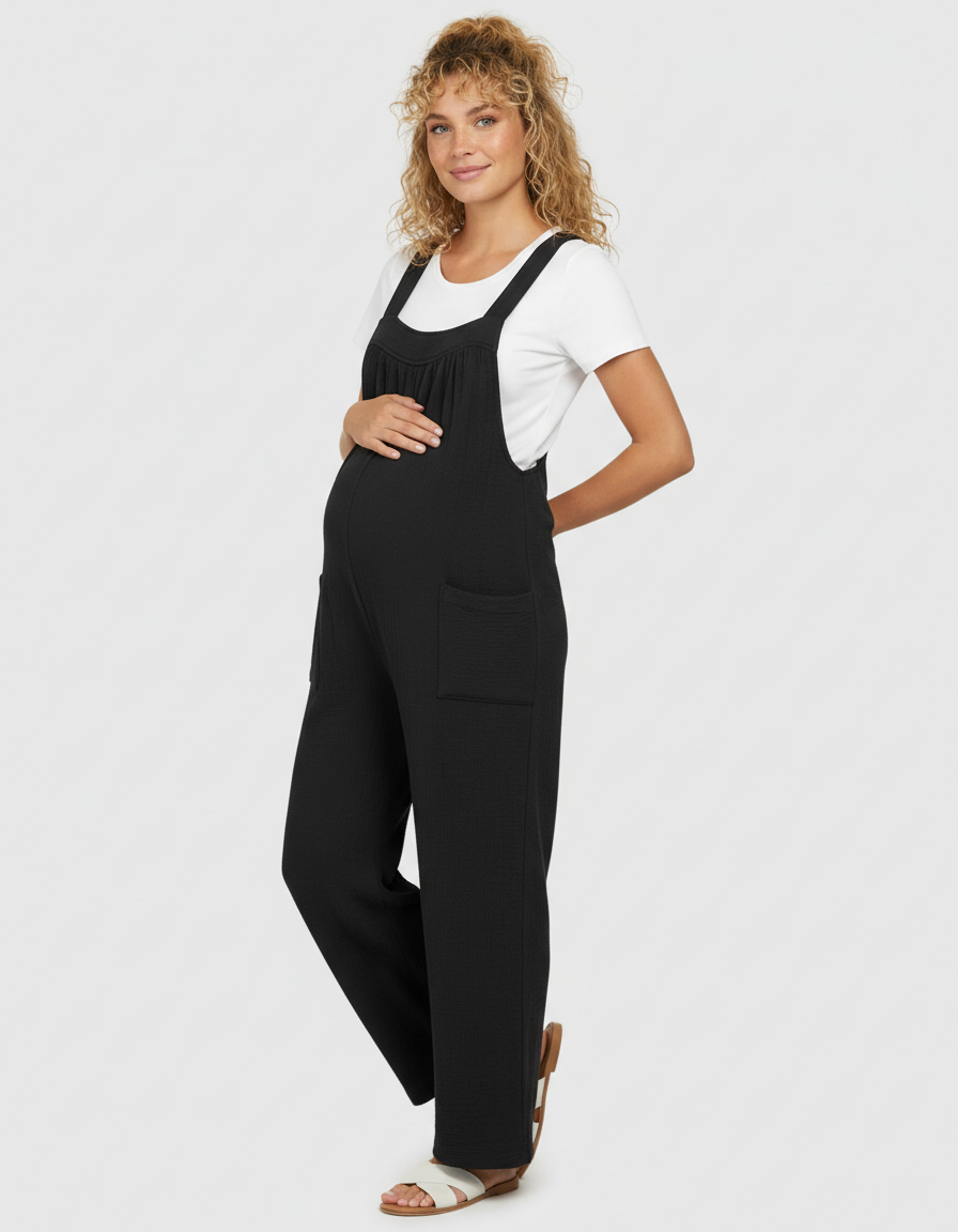 Pregnant woman in a black ribbed tie-back wide-leg maternity jumpsuit with a white tee.