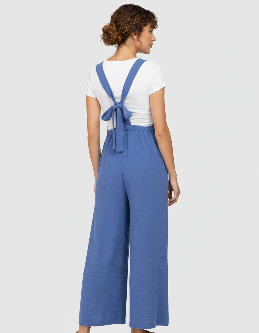 Woman in a blue tie-back wide-leg maternity jumpsuit with a white t-shirt underneath.