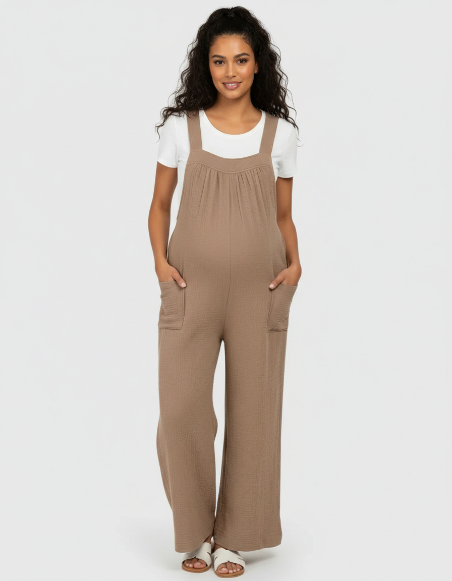 Maternity model in a brown textured wide-leg jumpsuit with front pockets, worn over a white tee.