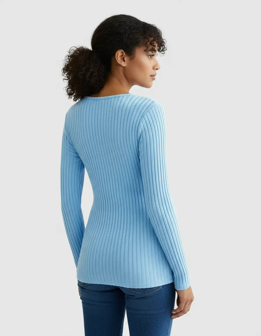 Woman in light blue ribbed long-sleeve maternity top with a tie-waist, paired with jeans.