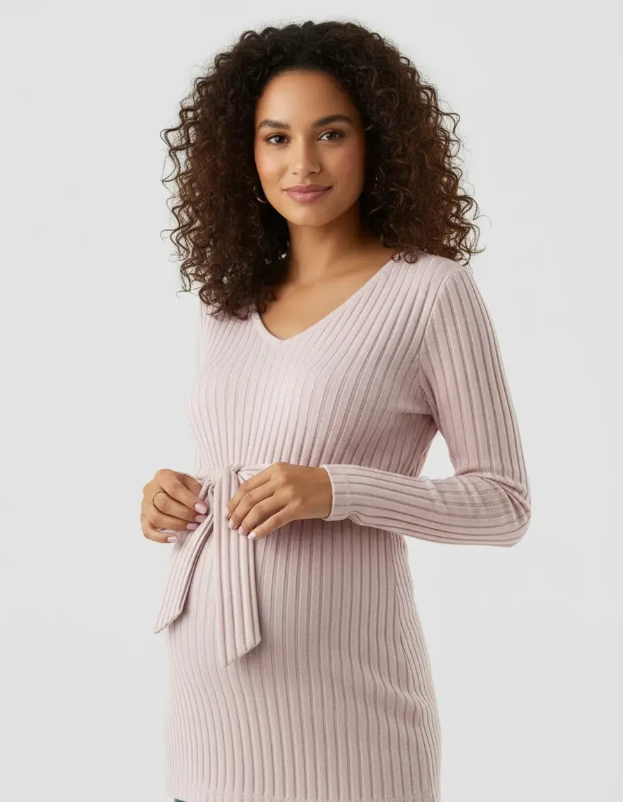 Smiling pregnant woman in a pink ribbed tie-waist maternity top with a V-neck and long sleeves.