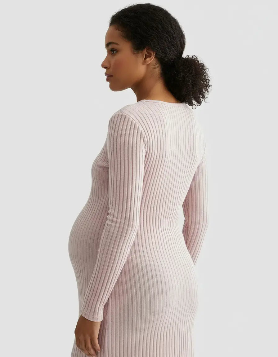 Pregnant woman in a light pink, long-sleeve, ribbed maternity top with a tie-waist design.