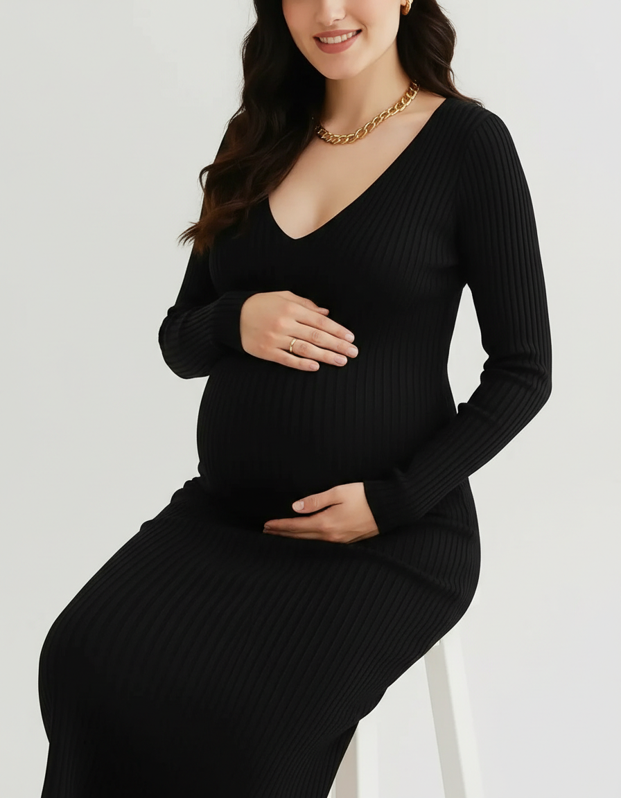 Pregnant woman in a black V-neck long sleeve ribbed maternity midi dress, gently holding her baby bump.