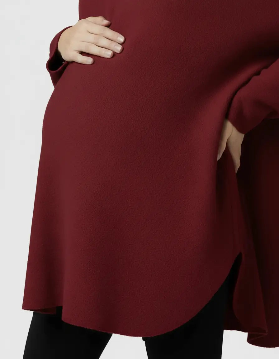 Pregnant woman wearing a relaxed fit, warm wool blend maternity sweater in a deep red color.