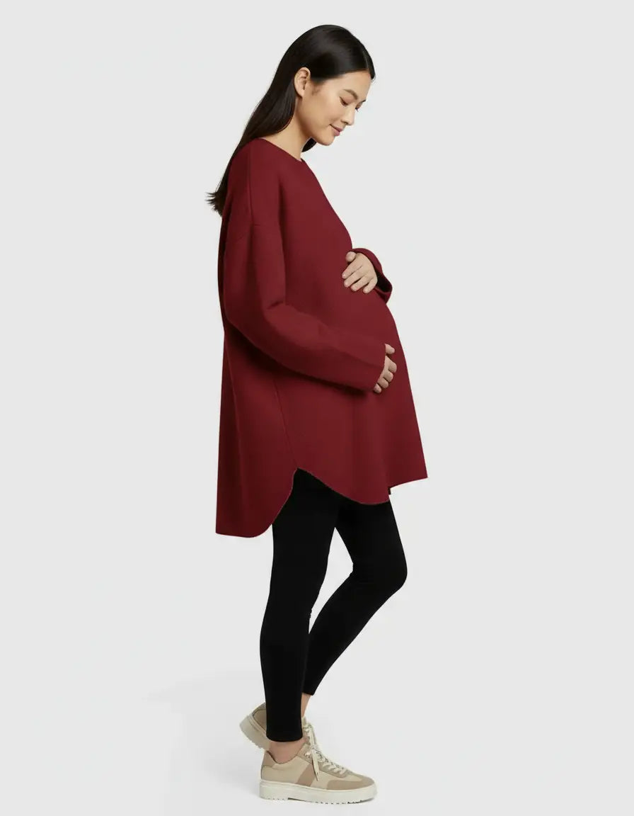 Pregnant woman in a relaxed fit, warm wool blend, red maternity sweater with a high-low hem.
