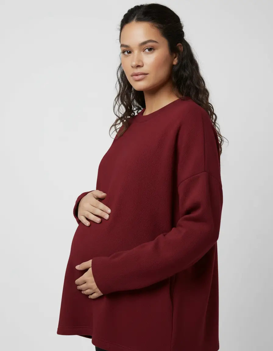 Pregnant woman in a relaxed fit, warm wool blend maternity sweater in a deep burgundy color.