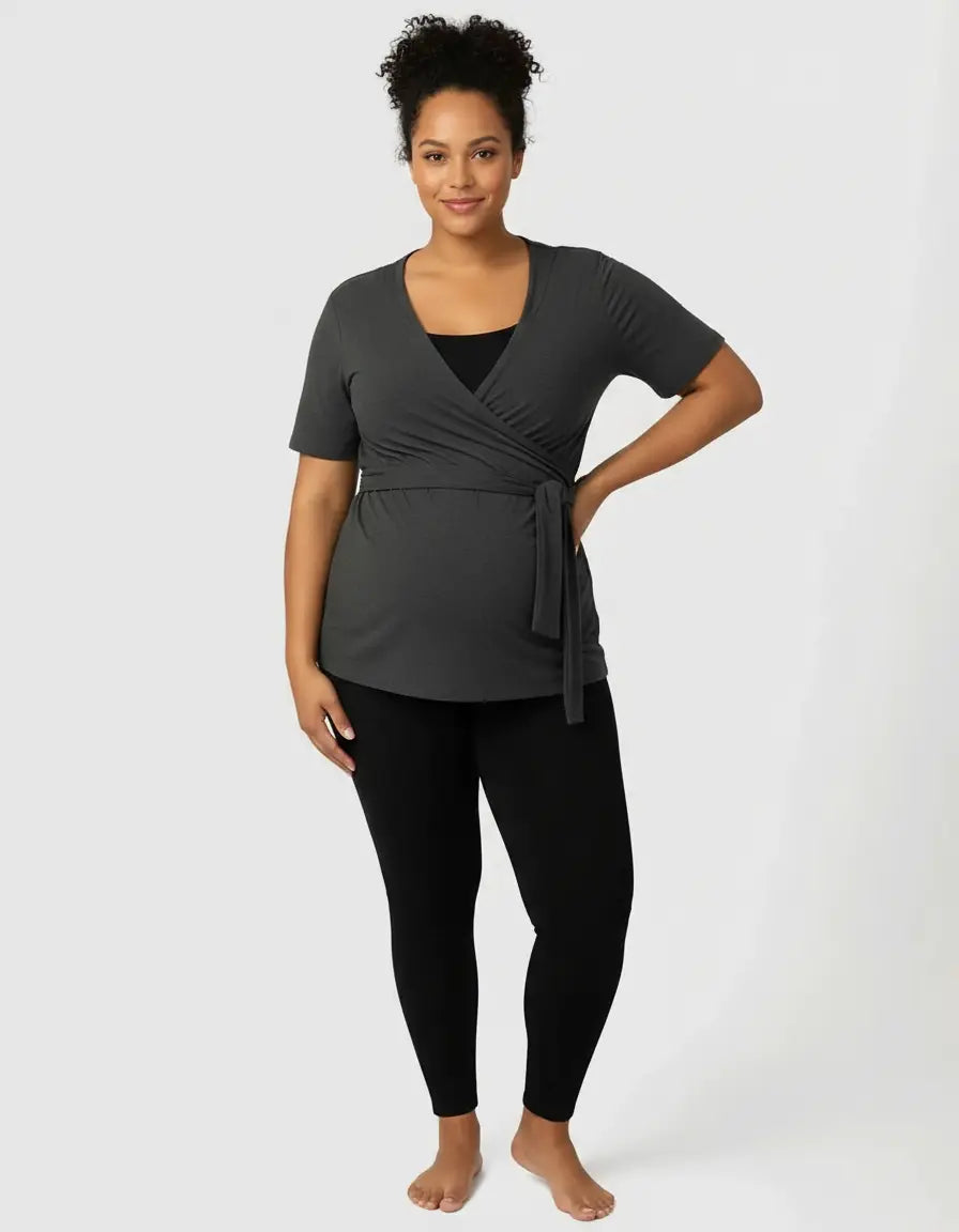 Woman in a charcoal gray 3-in-1 skin-to-skin nursing wrap top with a tie waist.