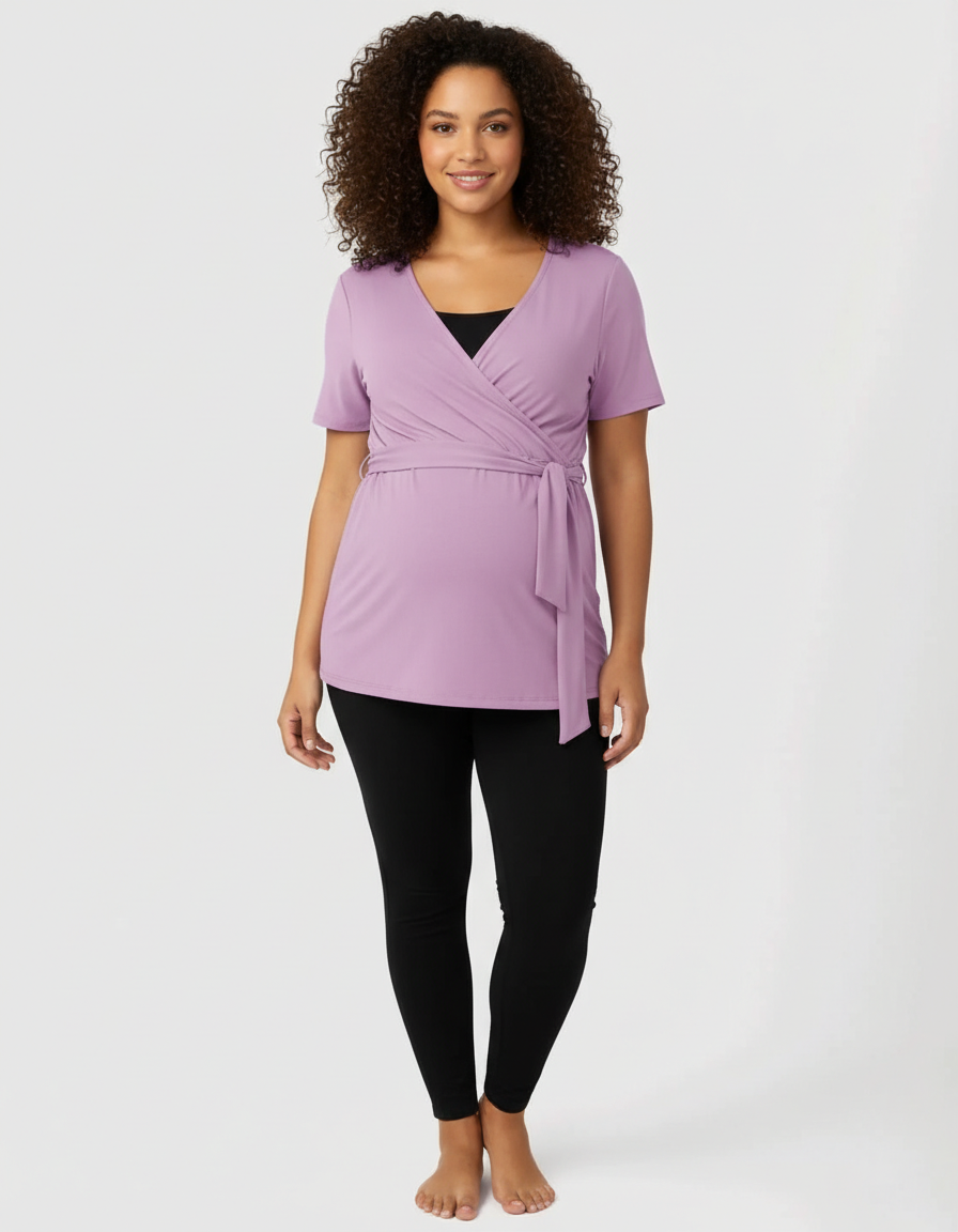 Smiling pregnant woman in a lavender 3-in-1 skin-to-skin nursing wrap top with black leggings.