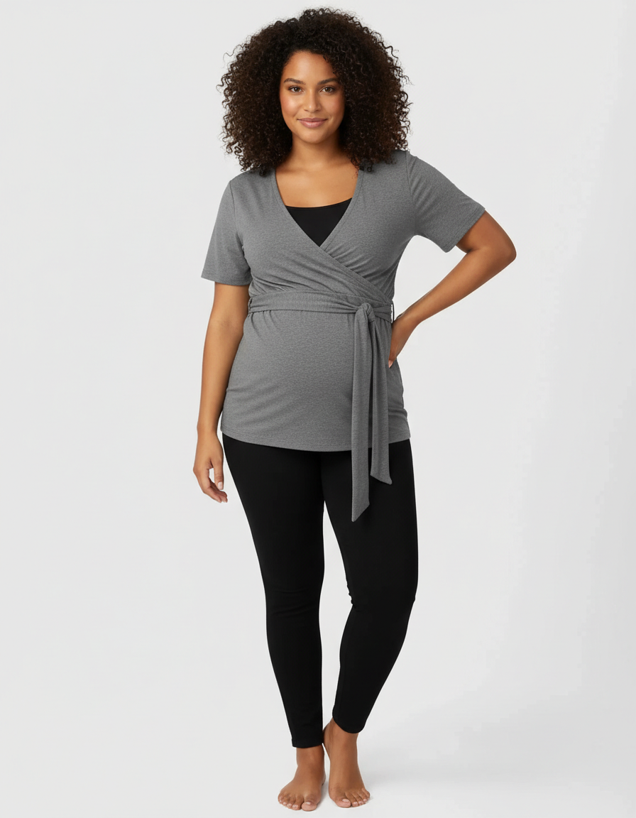 Smiling pregnant woman in a gray 3-in-1 skin-to-skin nursing wrap top with black leggings.