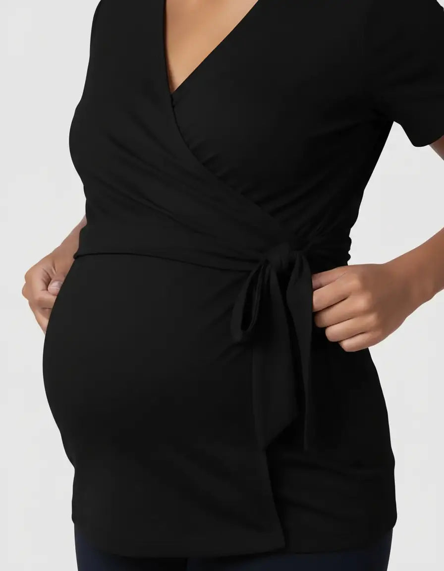 Black 3-in-1 skin-to-skin nursing wrap top with a tie waist, worn by a pregnant woman.