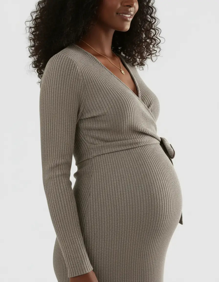 Pregnant woman in a taupe ribbed knit wrap midi dress with long sleeves and a tie waist.