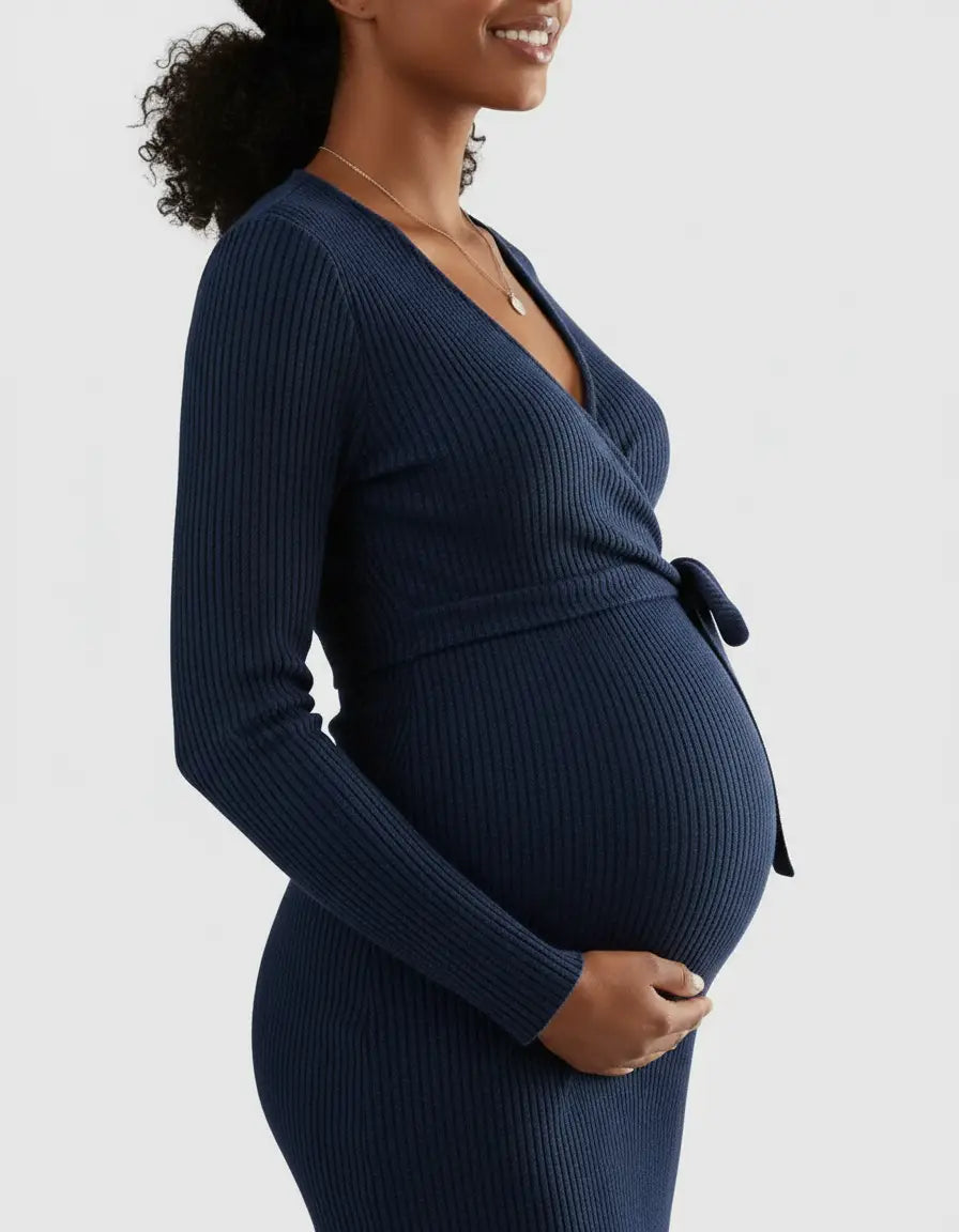Pregnant woman in a navy ribbed knit wrap midi dress with a tie waist.