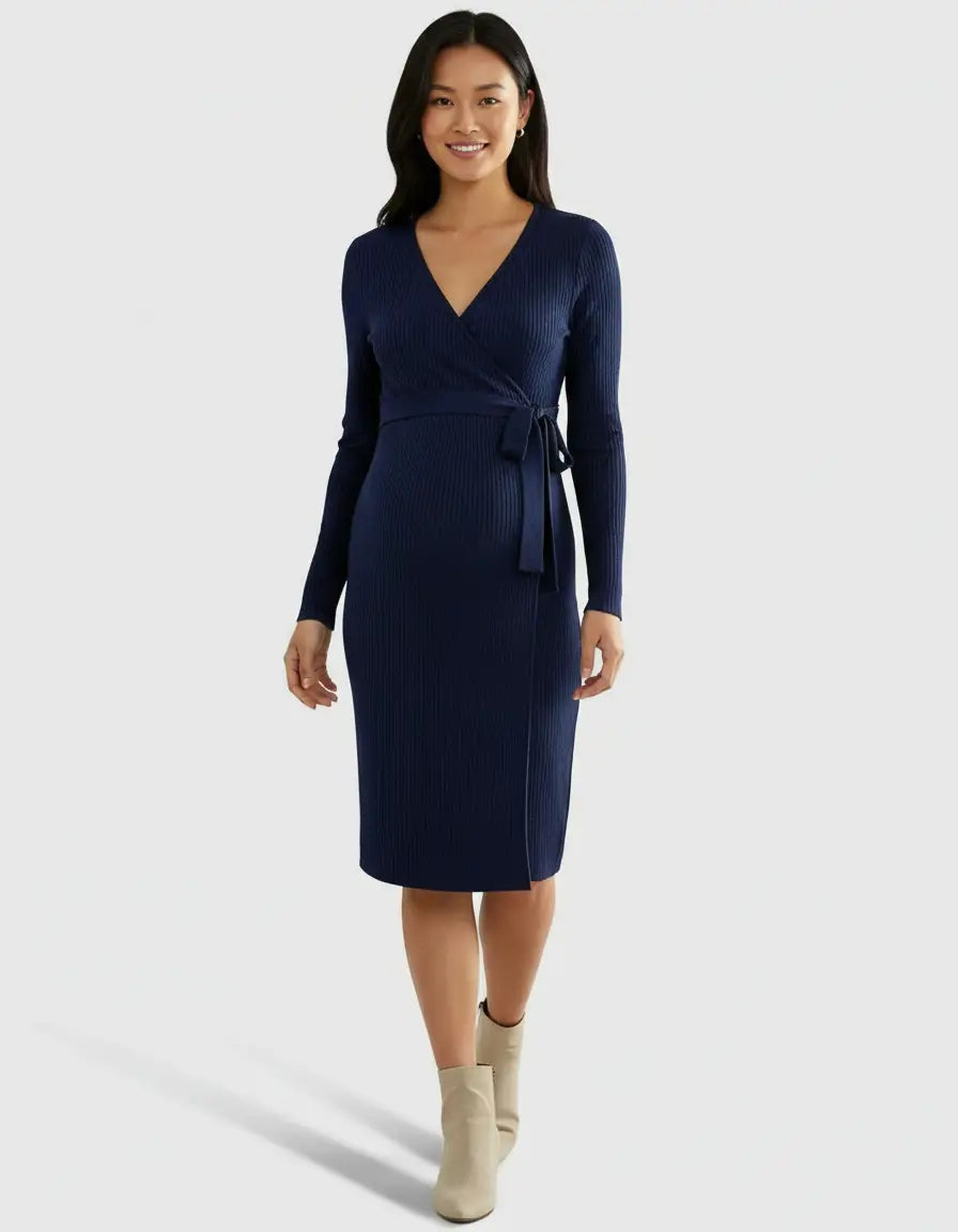 Smiling woman in a navy ribbed knit wrap midi dress with long sleeves and a tie waist.