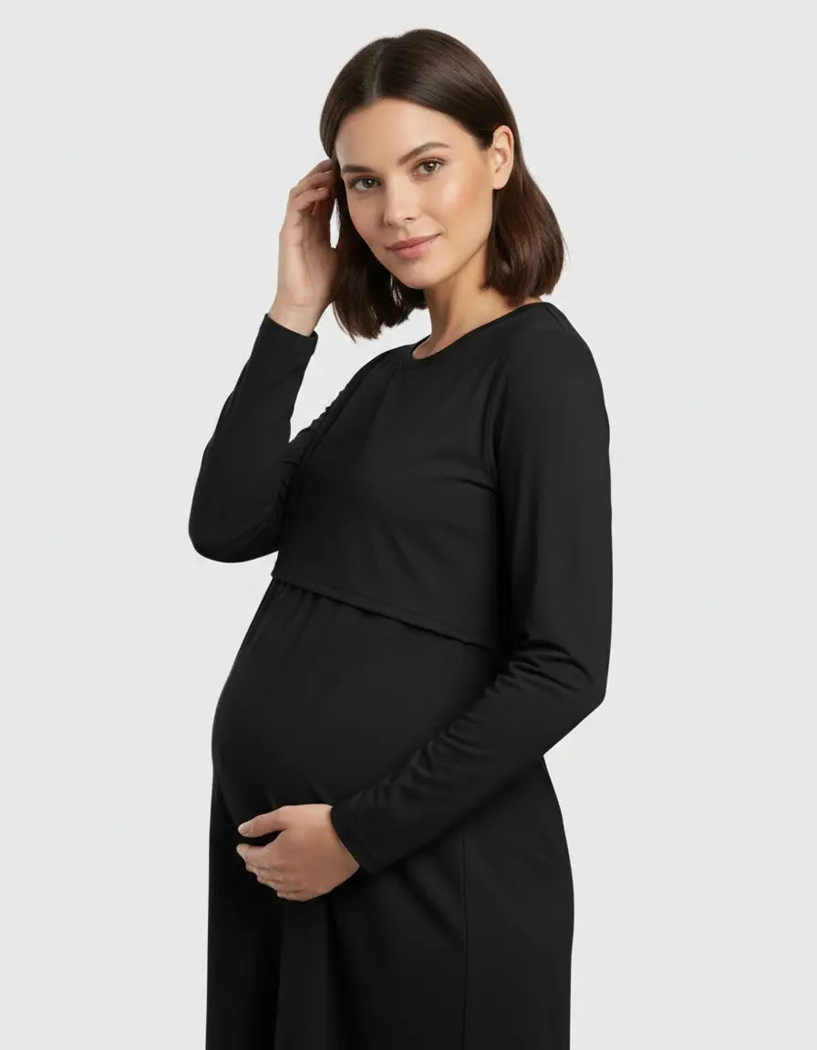 Pregnant woman in a black long-sleeve round neck nursing top with feeding port, holding her belly.