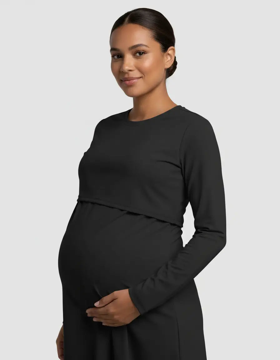 Smiling pregnant woman in a black long-sleeve round neck nursing top with feeding port.