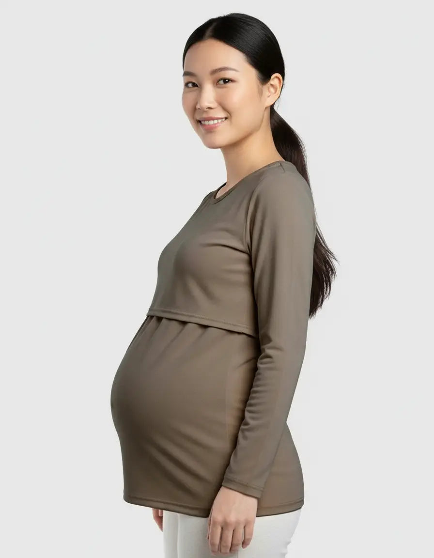 Smiling pregnant woman in a long-sleeved olive green round neck nursing top with feeding port.