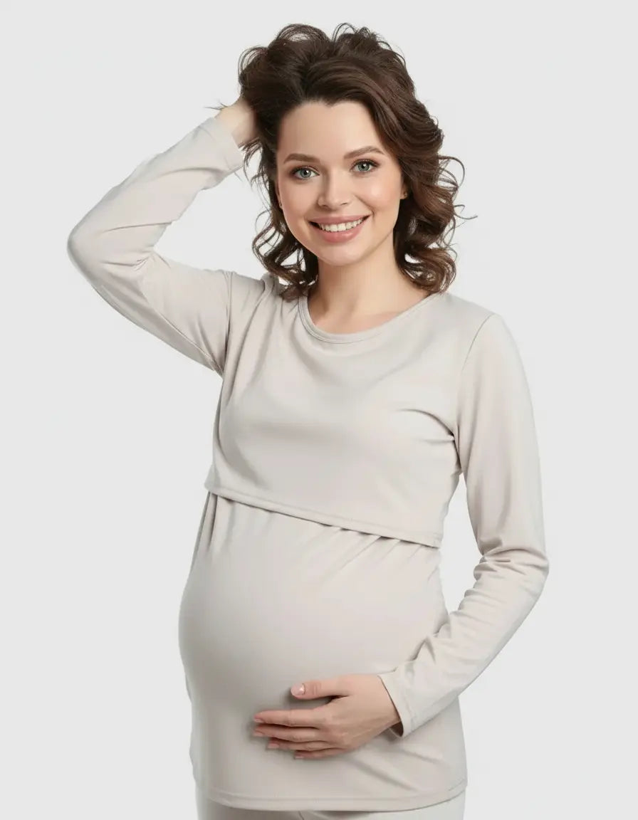 Smiling pregnant woman in a light beige, long-sleeve round neck nursing top with feeding port.