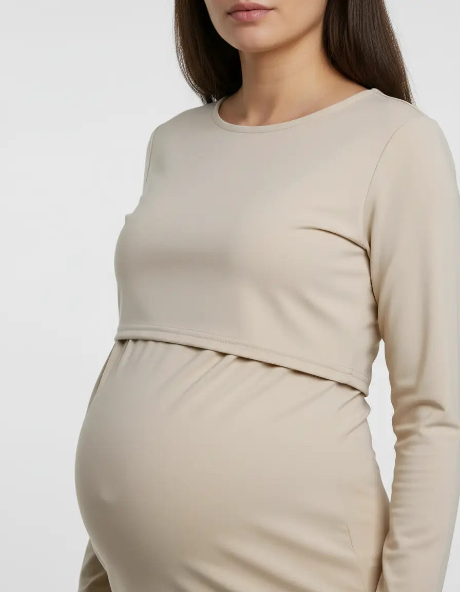 Beige long-sleeve round neck nursing top with feeding port, worn by a pregnant woman.