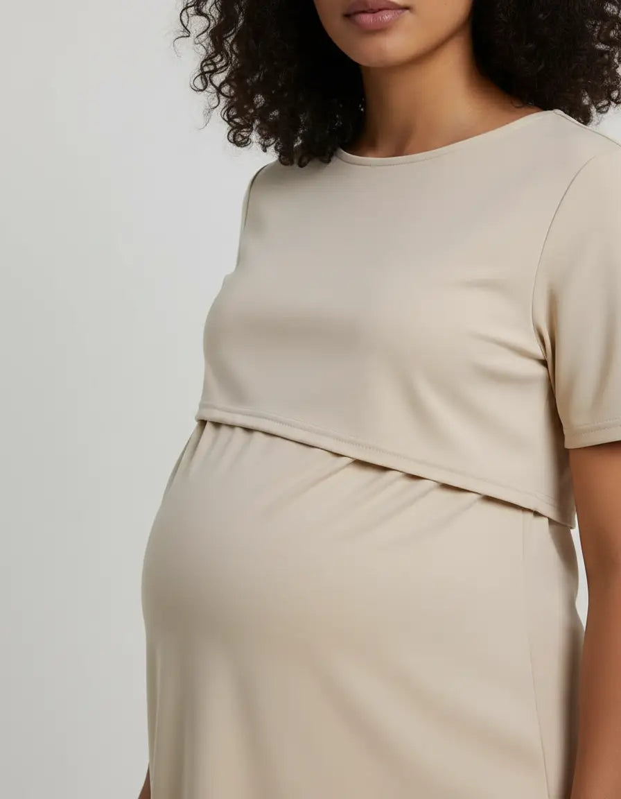 Pregnant woman wearing a beige round neck nursing top with a feeding port design.