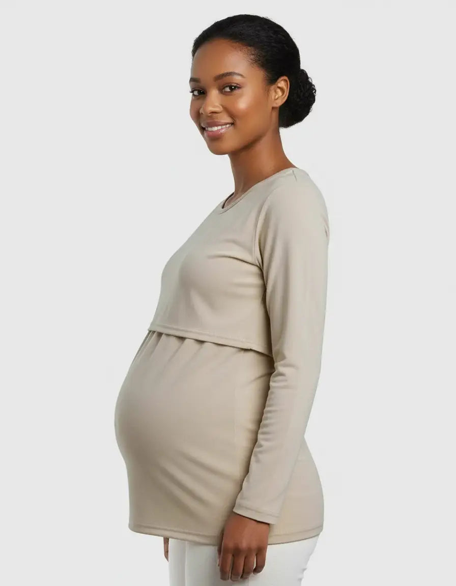 Smiling pregnant woman in a beige long-sleeve round neck nursing top with feeding port.