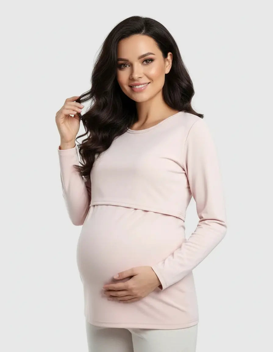 Smiling pregnant woman in a light pink long-sleeve round neck nursing top with feeding port.