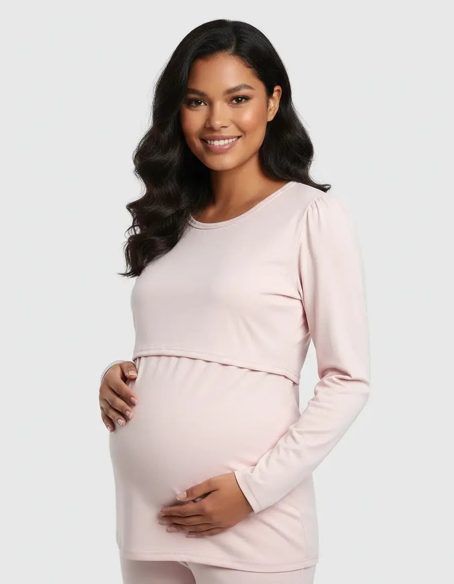 Smiling pregnant woman in a light pink long-sleeve round neck nursing top with feeding port.