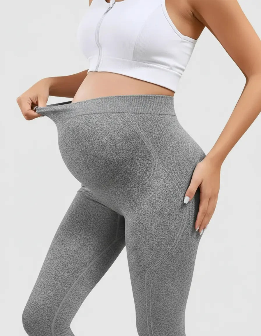Pregnant woman in grey belly-support sculpting maternity activewear leggings, showing stretchy fabric.