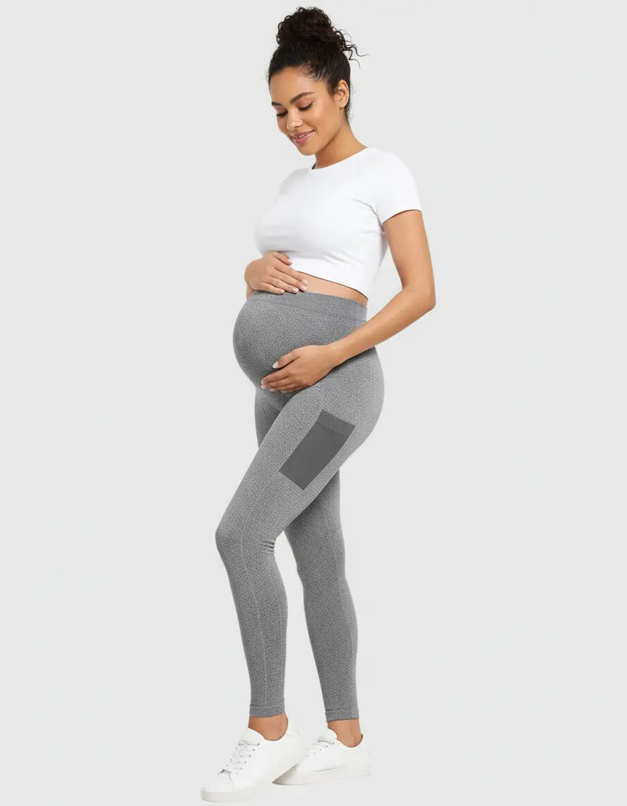 Smiling pregnant woman in gray belly-support sculpting maternity leggings with a side pocket.