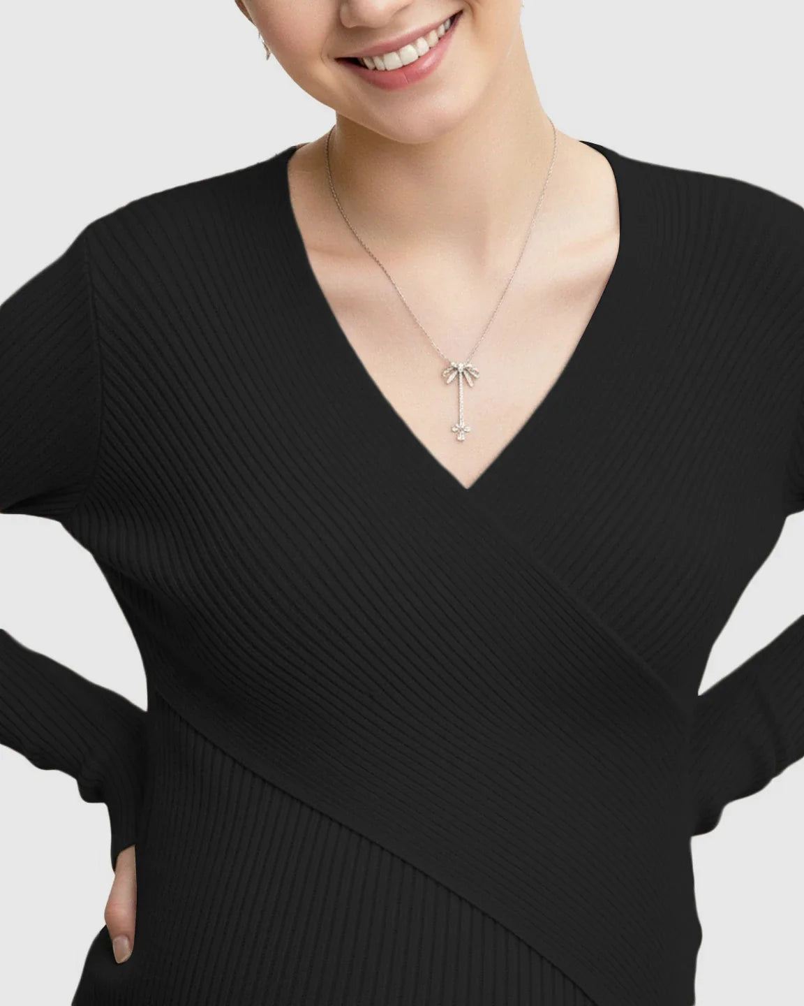 Black faux-wrap ribbed maternity top with V-neck and long sleeves, worn by a smiling woman.