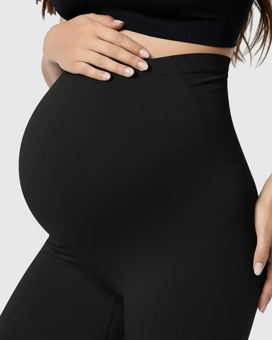 Pregnant woman wearing black, high-waisted Belly Support Stretch Maternity Leggings with ribbed waist.