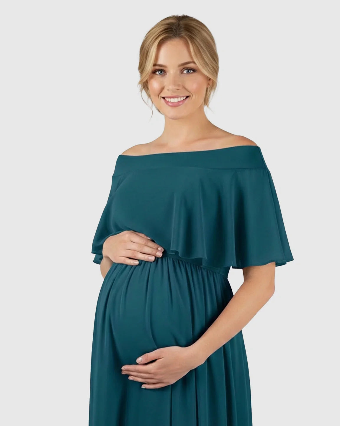 Smiling pregnant woman in a teal chiffon off-shoulder bohemian maternity photoshoot dress.