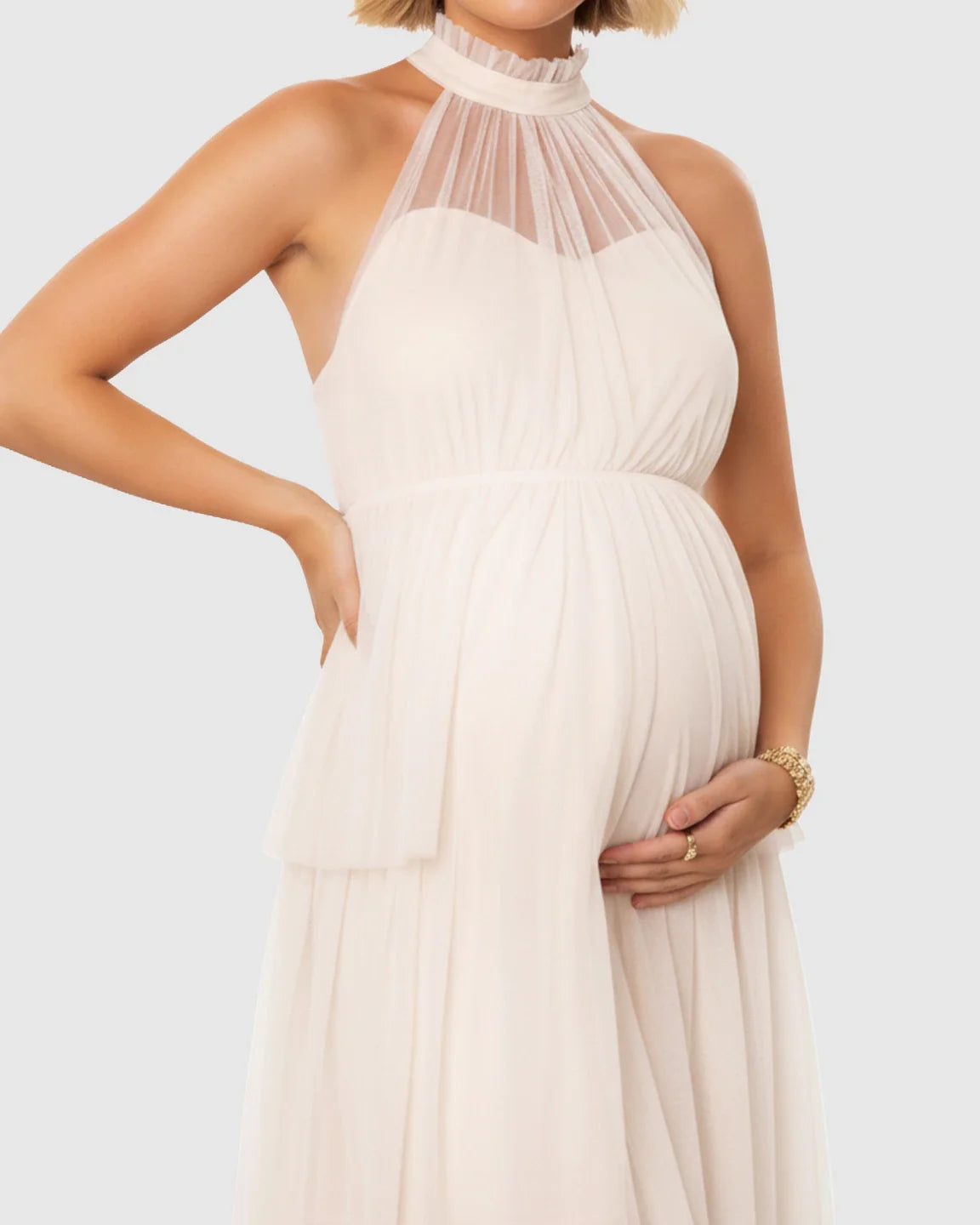 Elegant ivory halter neck tiered mesh maternity gown, flattering the bump with a flowing skirt.