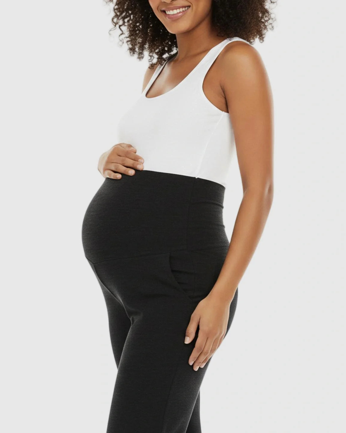 Pregnant woman in black wide-leg maternity lounge pants with foldable waistband and side pockets.