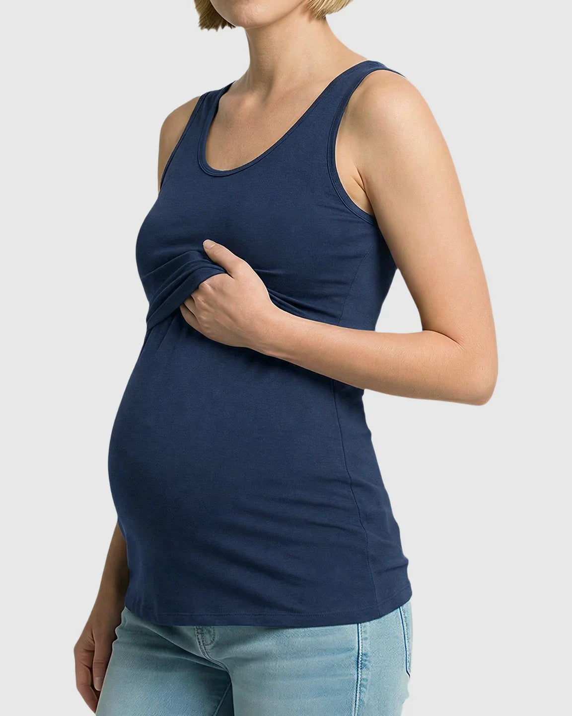 Pregnant woman in a navy blue stretch nursing-access maternity tank top, showing discreet nursing feature.