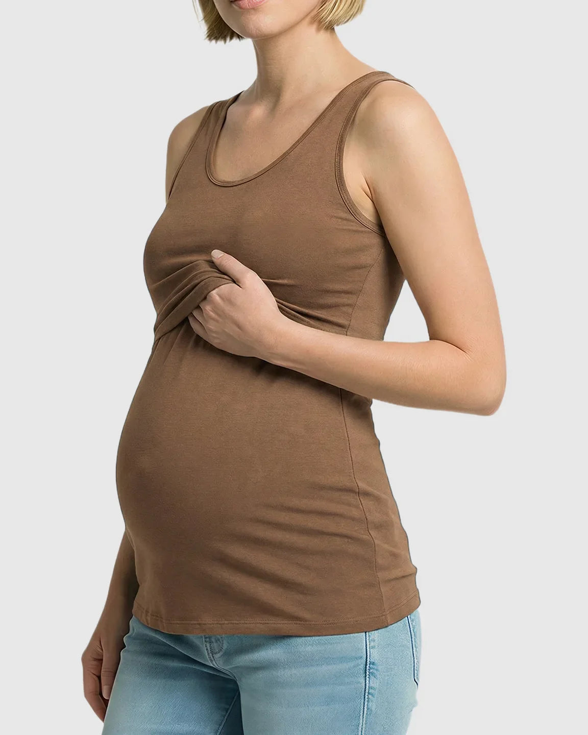 Pregnant woman in a brown stretch nursing-access maternity tank top, demonstrating discreet lift-up access.