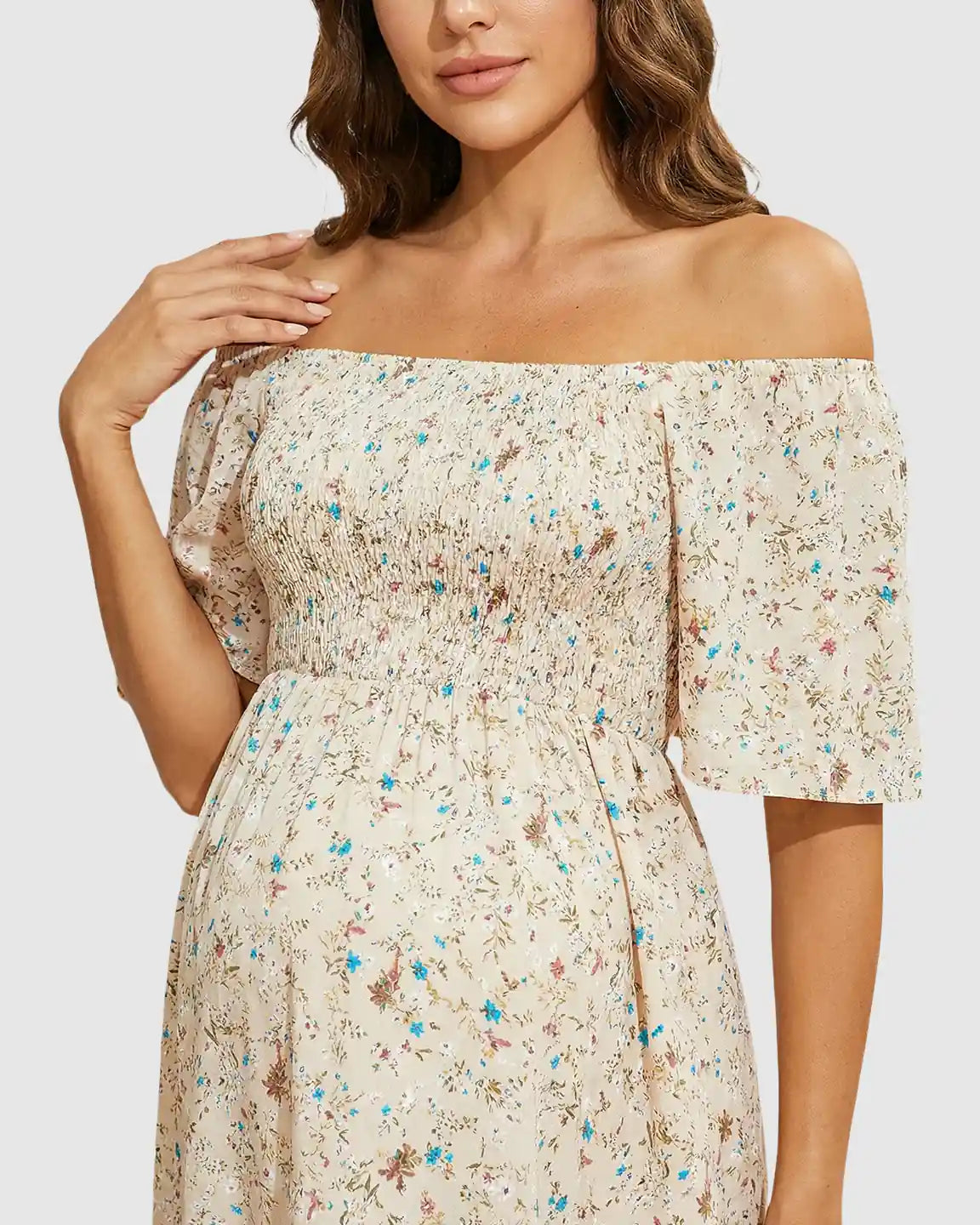 Maternity midi dress with off-shoulder smocked top, flutter sleeves, and a floral print on a light background.