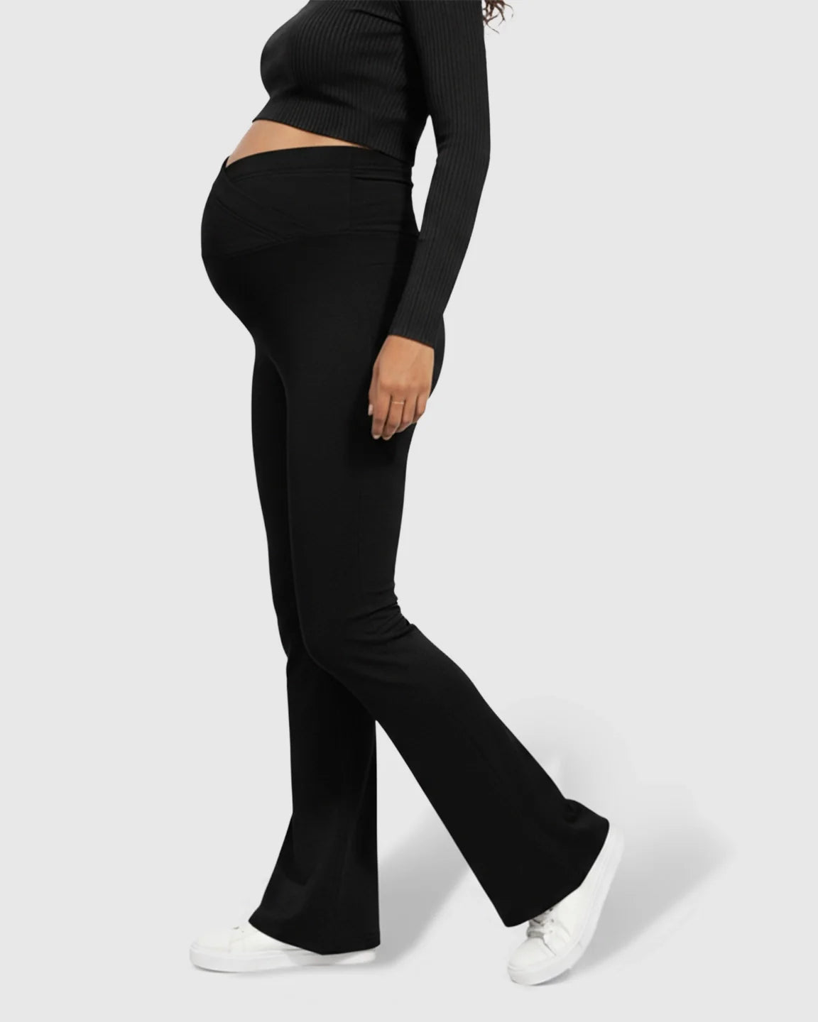 Black Bump Society maternity flared pants with a crossed waistband, worn by a pregnant woman.