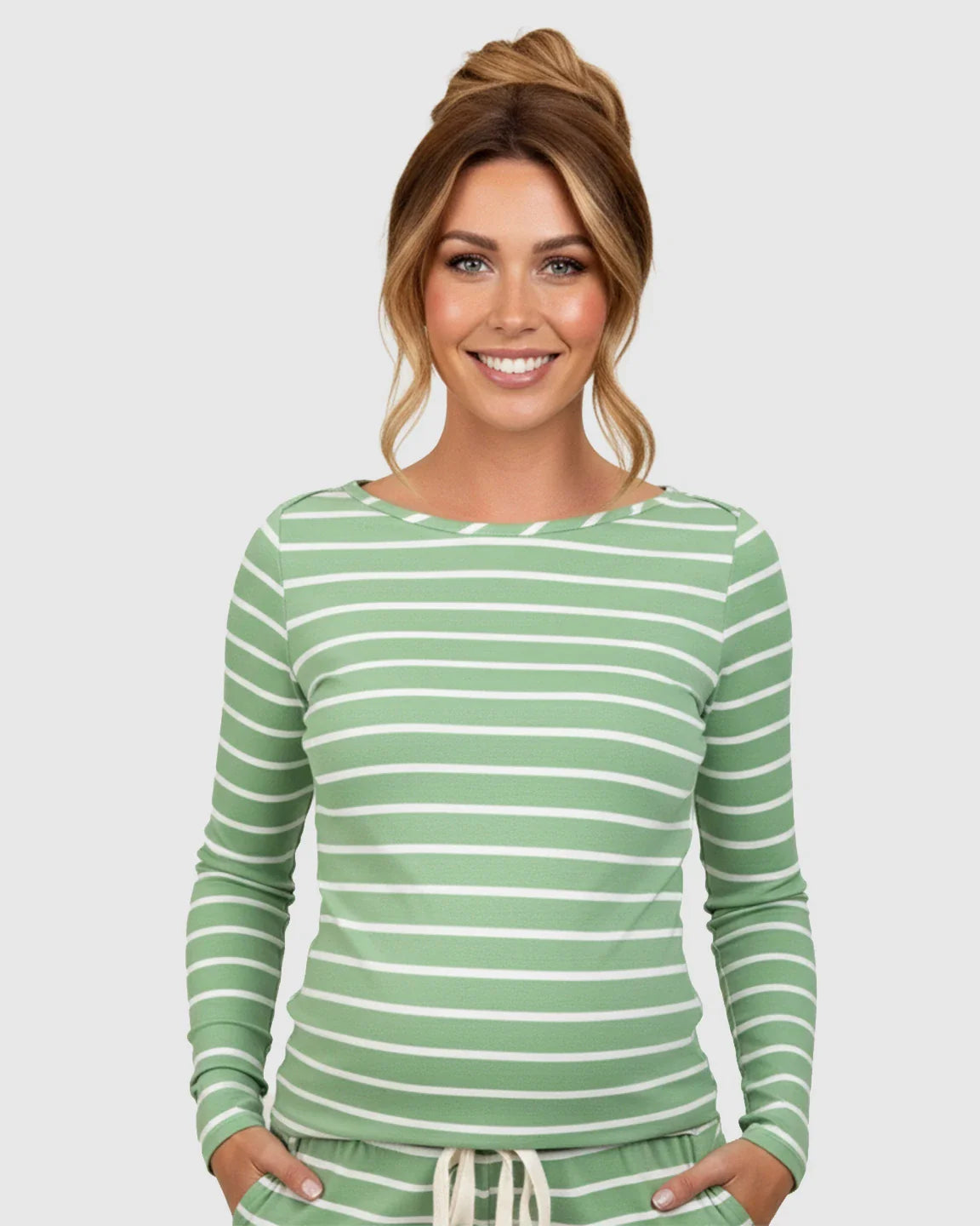 Woman smiling in a green and white striped long-sleeve maternity top and matching lounge shorts.