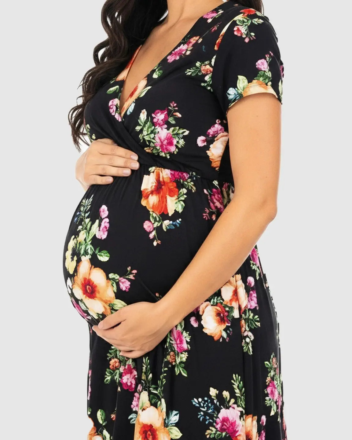 Maternity maxi dress in black with vibrant floral print, V-neck, short sleeves, and comfortable cotton-blend fabric.