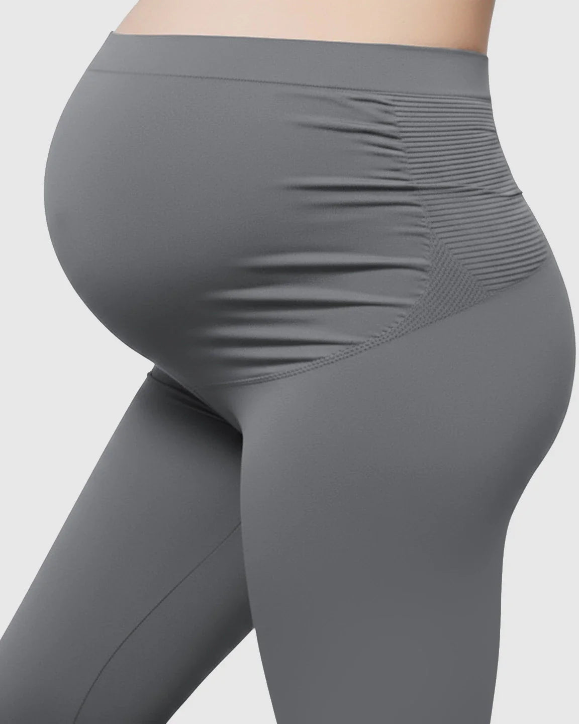 Gray high-waist maternity support leggings on a pregnant torso, showing seamless design and belly support.